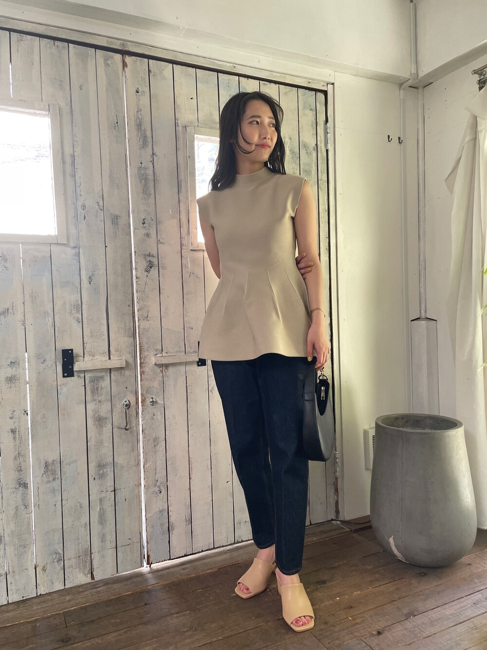 ベージュ系のニット/セーター、ブルー系のデニムパンツ、ベージュ系のサンダルを着用したレディースの春コーディネートの3枚目の写真