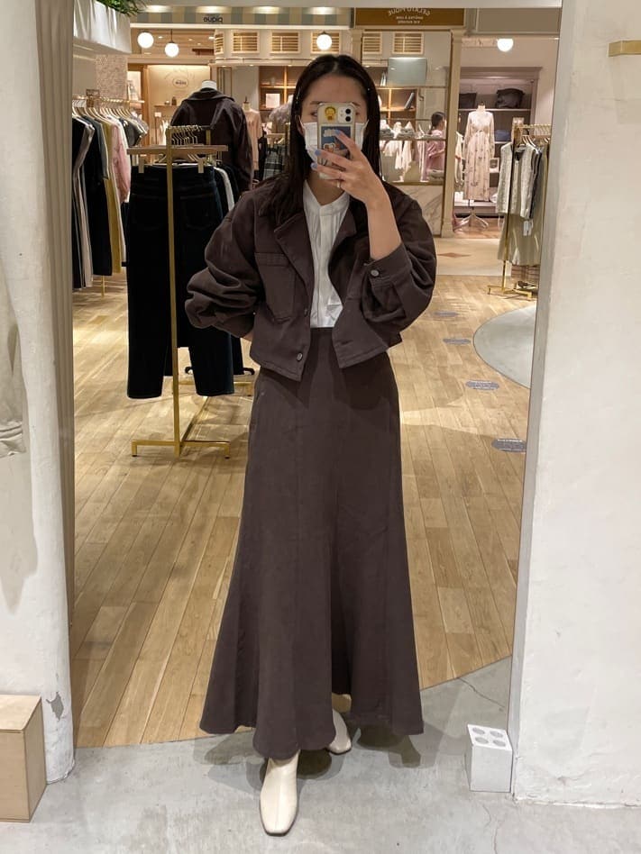 ブラウン系のデニムジャケット、ホワイト系のシャツ/ブラウス、ブラウン系のスカートを着用したレディースの夏コーディネートの3枚目の写真