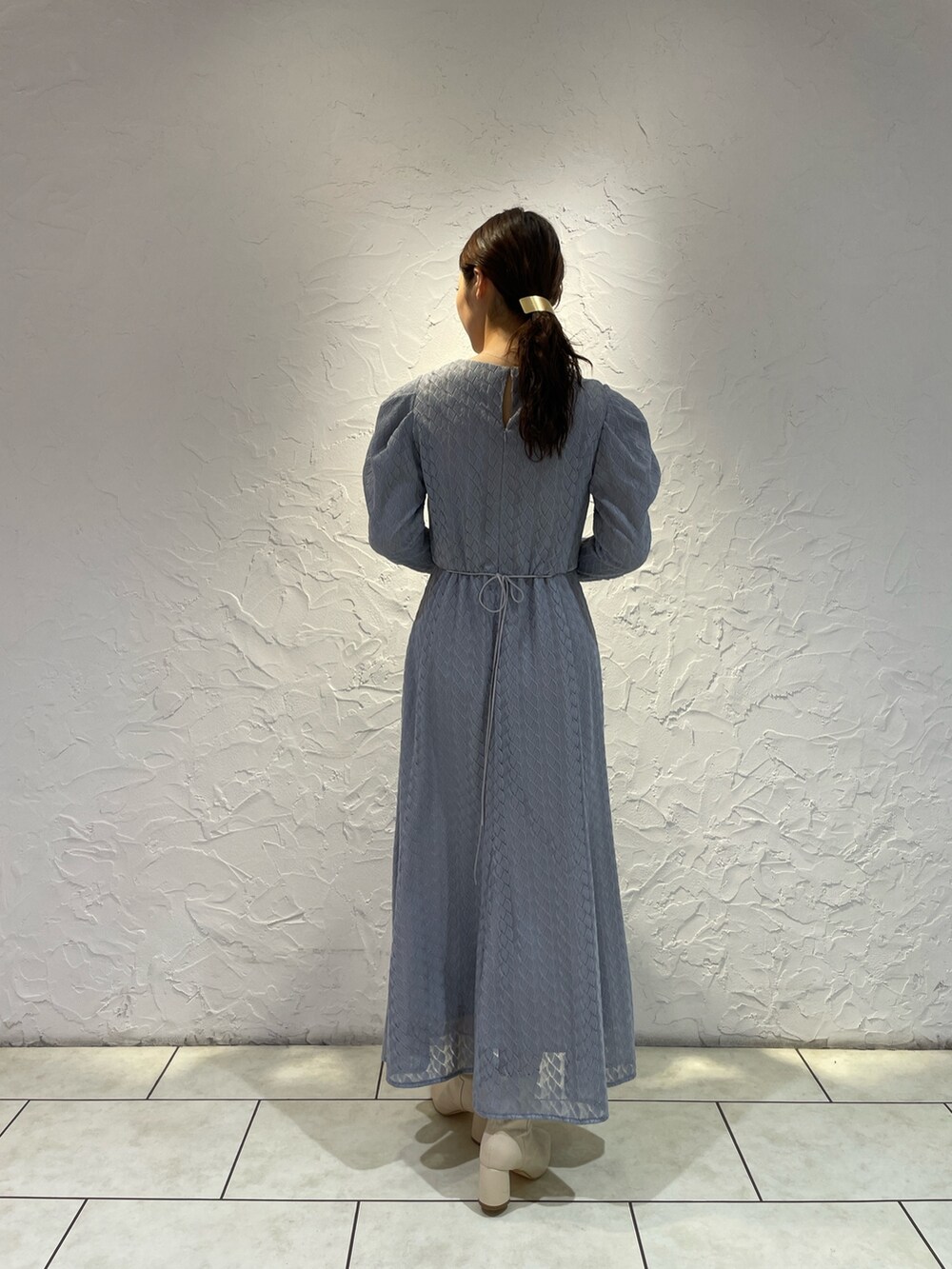 ホワイト系のブーツ、ブルー系のワンピースを着用したレディースの冬コーディネートの6枚目の写真