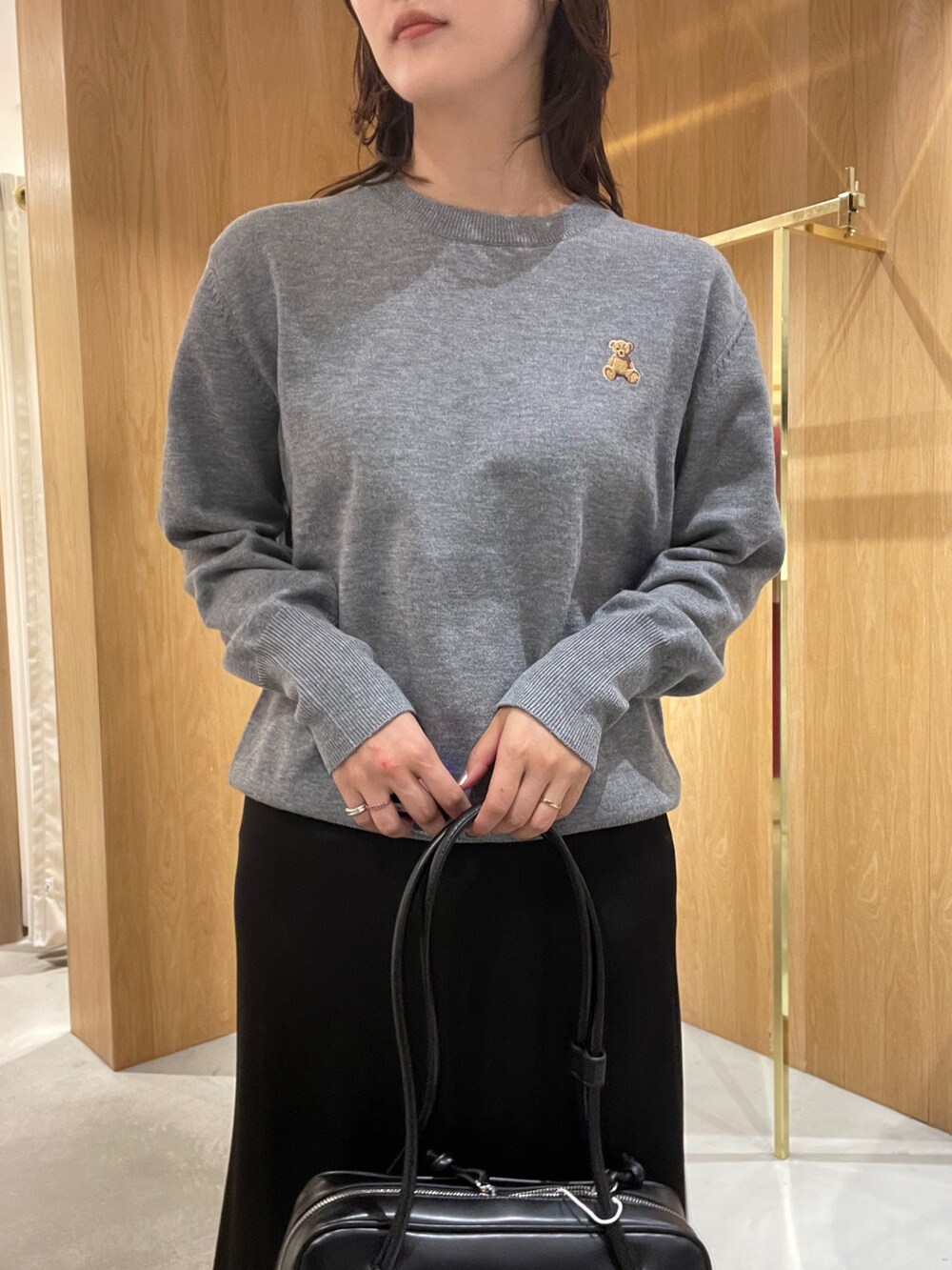 グレー系のニット/セーター、ブラック系のスカート、ブラック系のローファーを着用したレディースの秋コーディネートの7枚目の写真