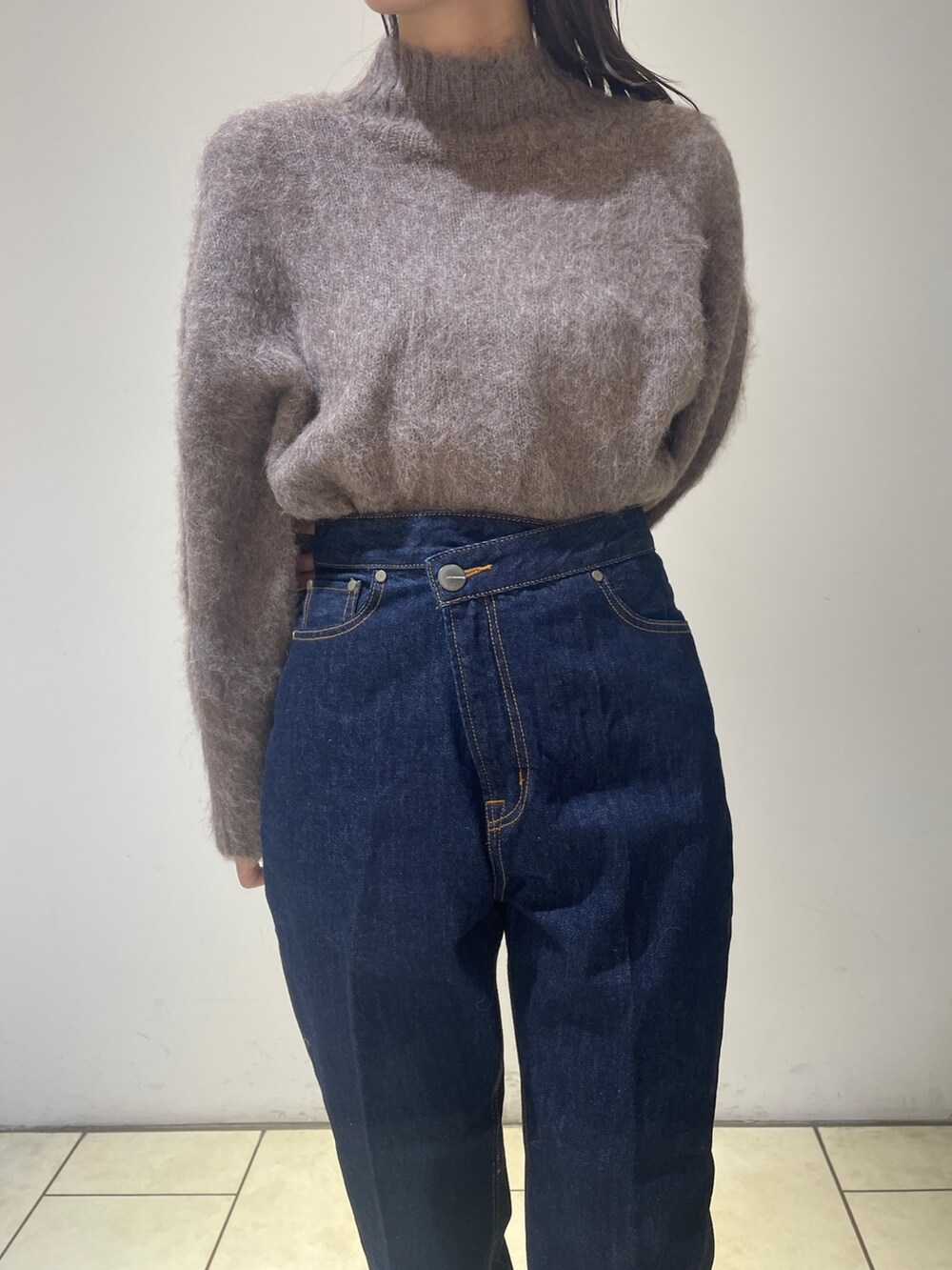 ブラウン系のニット/セーター、ベージュ系のブーツ、ブルー系のデニムパンツを着用したレディースの秋コーディネートの5枚目の写真