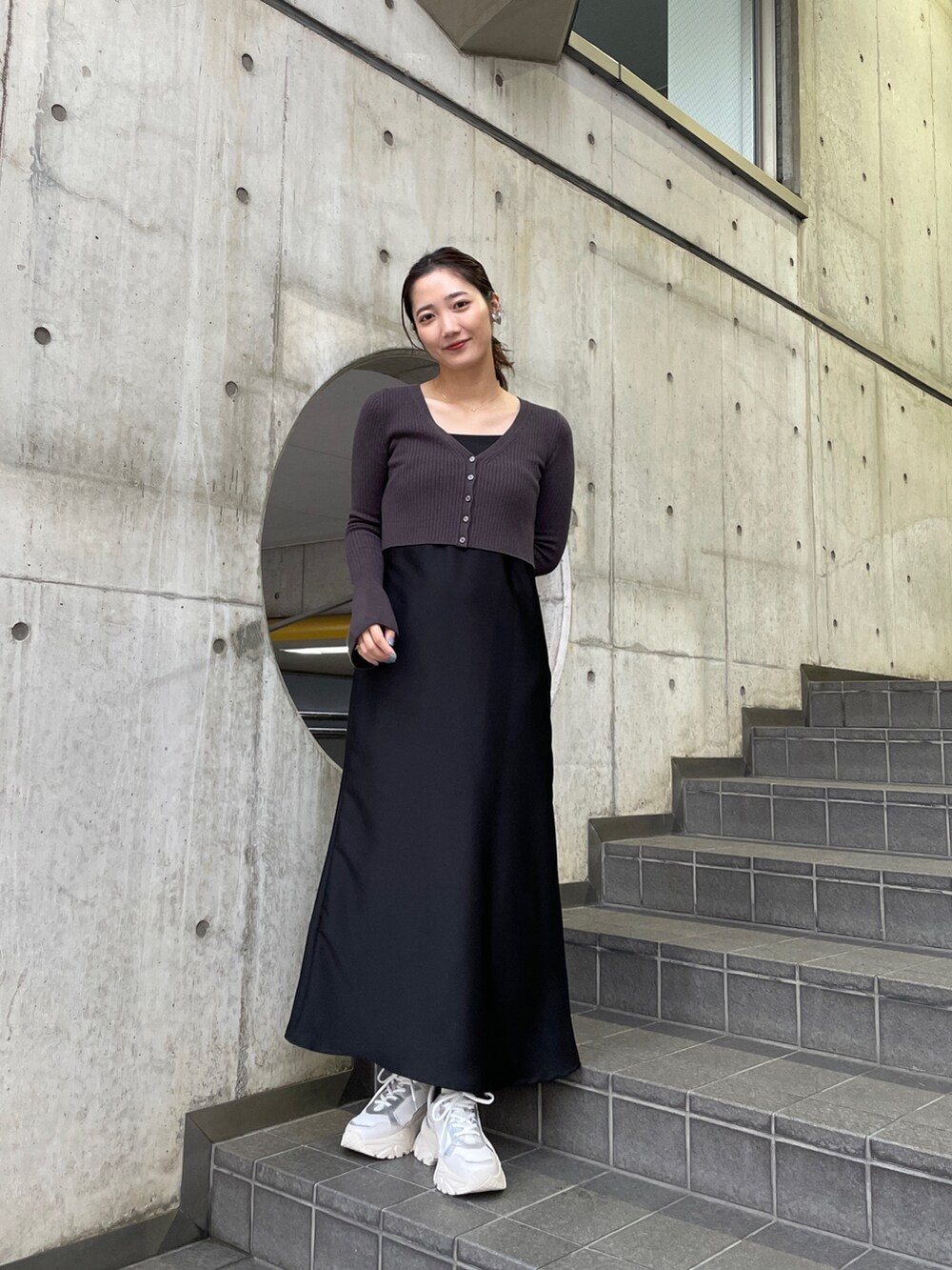 ホワイト系のスニーカー、ブラック系のワンピースを着用したレディースの冬コーディネートの2枚目の写真