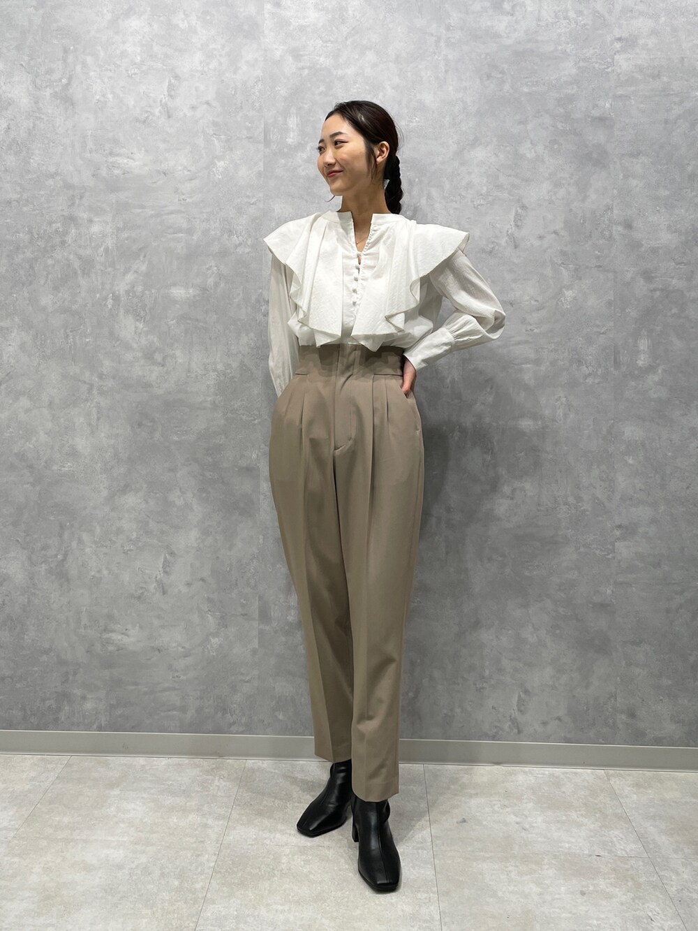 ホワイト系のカーディガン/ボレロ、ブラック系のブーツ、ホワイト系のシャツ/ブラウスを着用したレディースの冬コーディネートの4枚目の写真