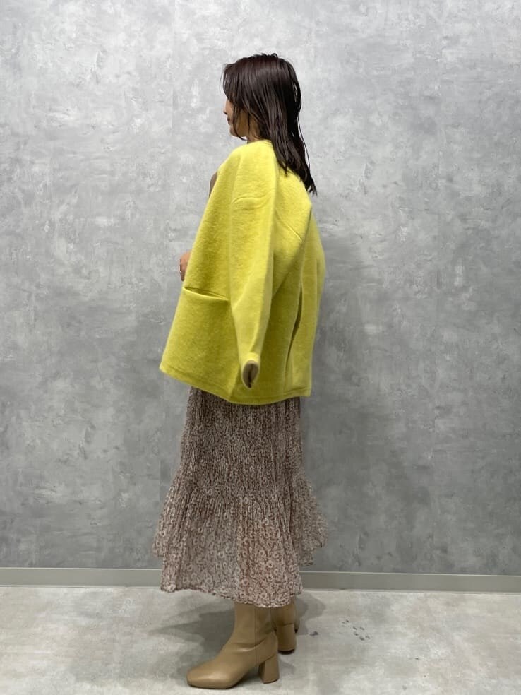 ベージュ系のワンピース、ベージュ系のブーツ、イエロー系のカーディガン/ボレロを着用したレディースの秋コーディネートの4枚目の写真