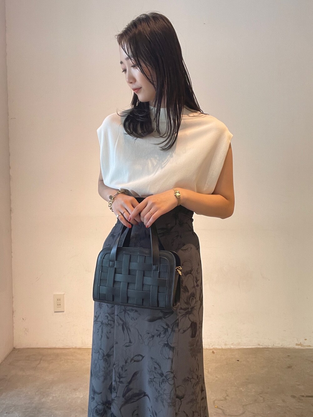 ホワイト系のニット/セーター、ブラック系のショルダーバッグ、イエロー系のサンダルを着用したレディースの夏コーディネートの8枚目の写真