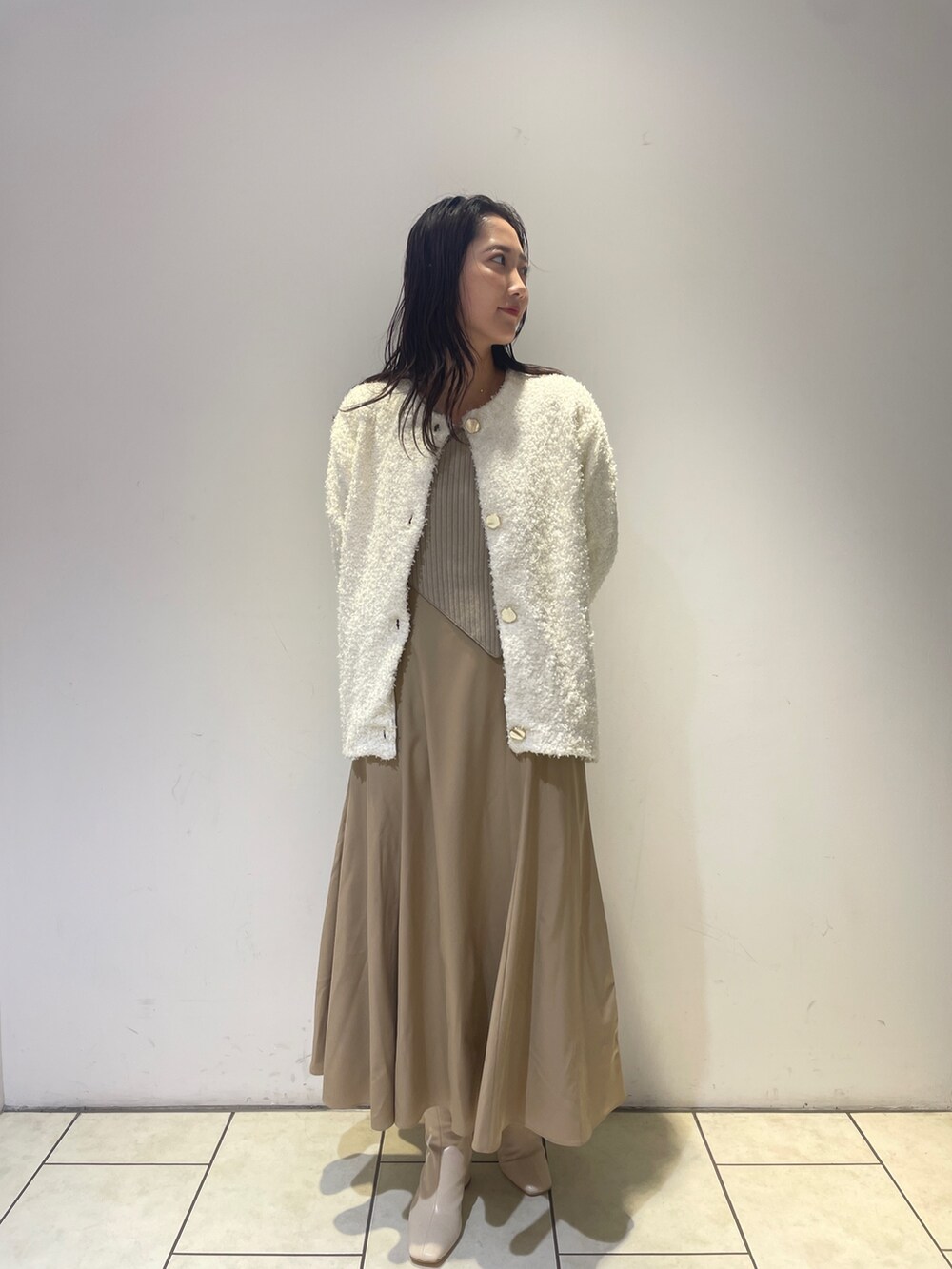ベージュ系のワンピース、ホワイト系のブーツ、ホワイト系のカーディガン/ボレロを着用したレディースの秋コーディネートの3枚目の写真
