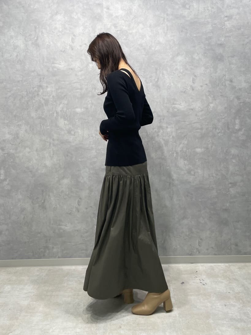 ベージュ系のスカート、ベージュ系のブーツ、ブラック系のニット/セーターを着用したレディースの秋コーディネートの5枚目の写真