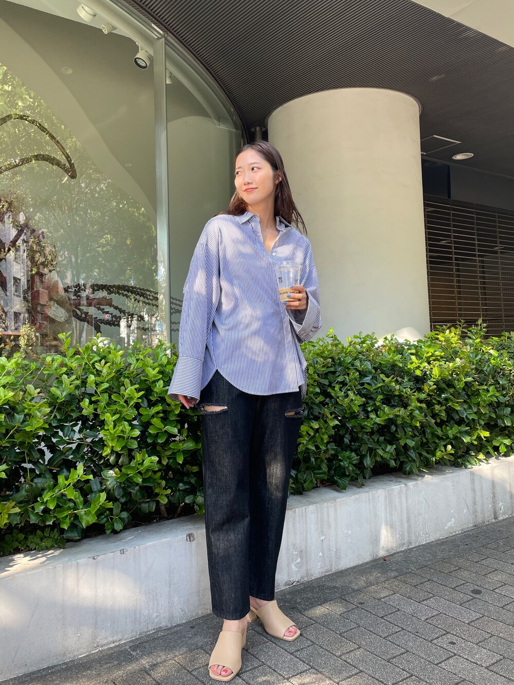 ブラック系のデニムパンツ、ベージュ系のサンダル、ブラック系のシャツ/ブラウスを着用したレディースの夏コーディネートの2枚目の写真