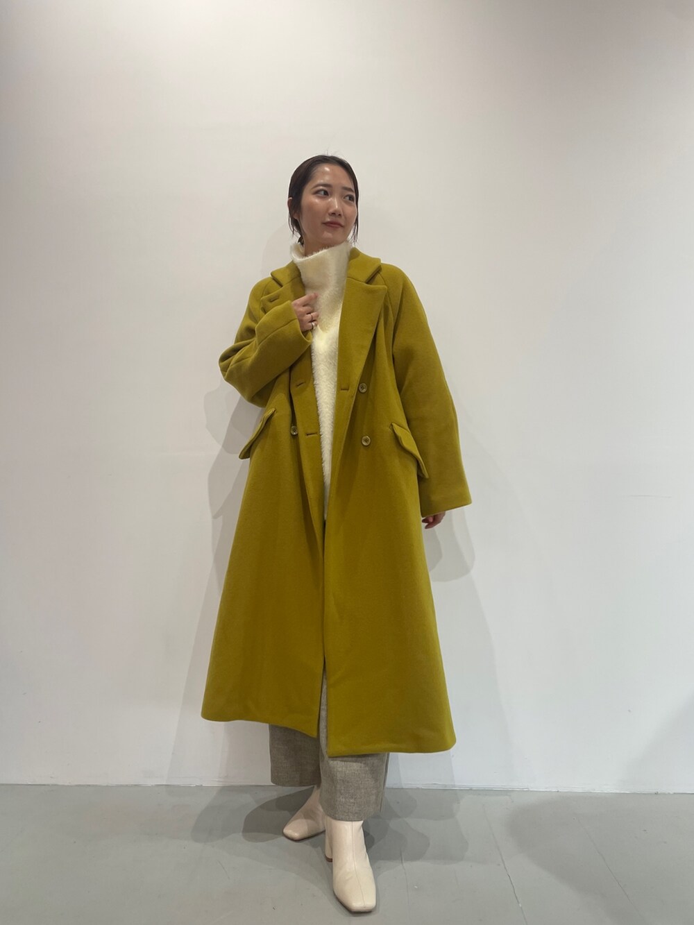 ホワイト系のニット/セーター、ベージュ系のその他パンツ、ホワイト系のブーツを着用したレディースの夏コーディネートの4枚目の写真