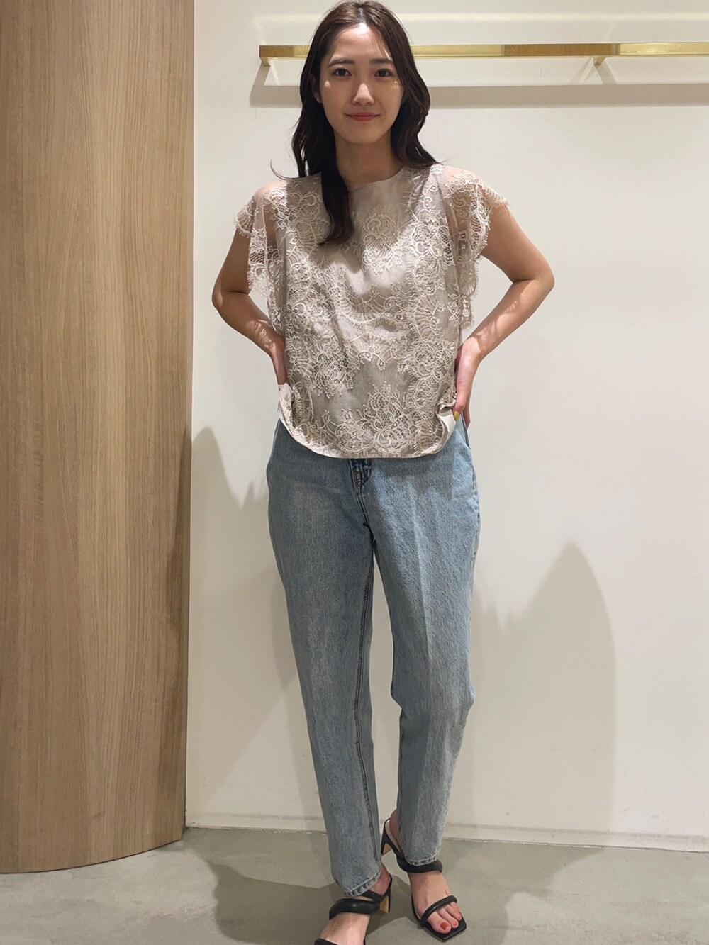 ベージュ系のシャツ/ブラウス、ブルー系のデニムパンツ、ブラック系のサンダルを着用したレディースの春コーディネートの3枚目の写真