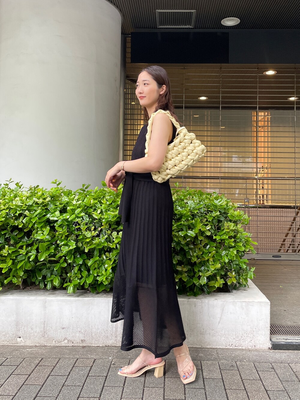 ブラック系のシャツ/ブラウス、ベージュ系のハンドバッグ、ブラック系のワンピースを着用したレディースの春コーディネートの7枚目の写真