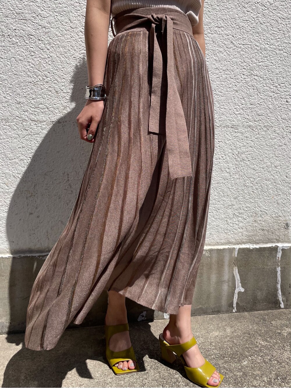 グリーン系のサンダル、ブラウン系のスカート、ホワイト系のニット/セーターを着用したレディースの春コーディネートの4枚目の写真