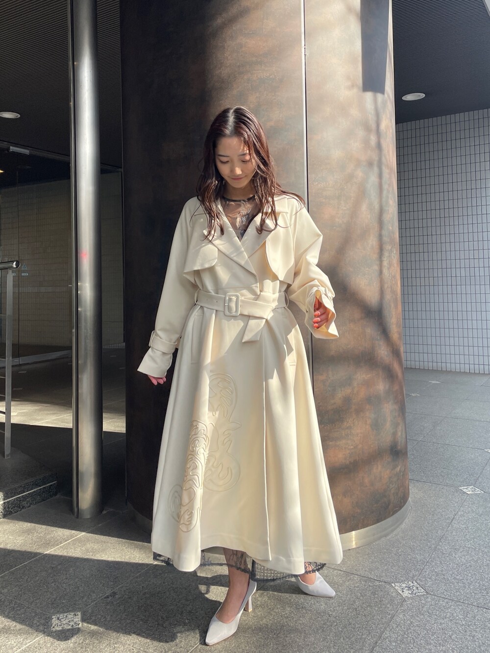 グレー系のドレス、グレー系のパンプス、ホワイト系のトレンチコートを着用したレディースの冬コーディネートの4枚目の写真