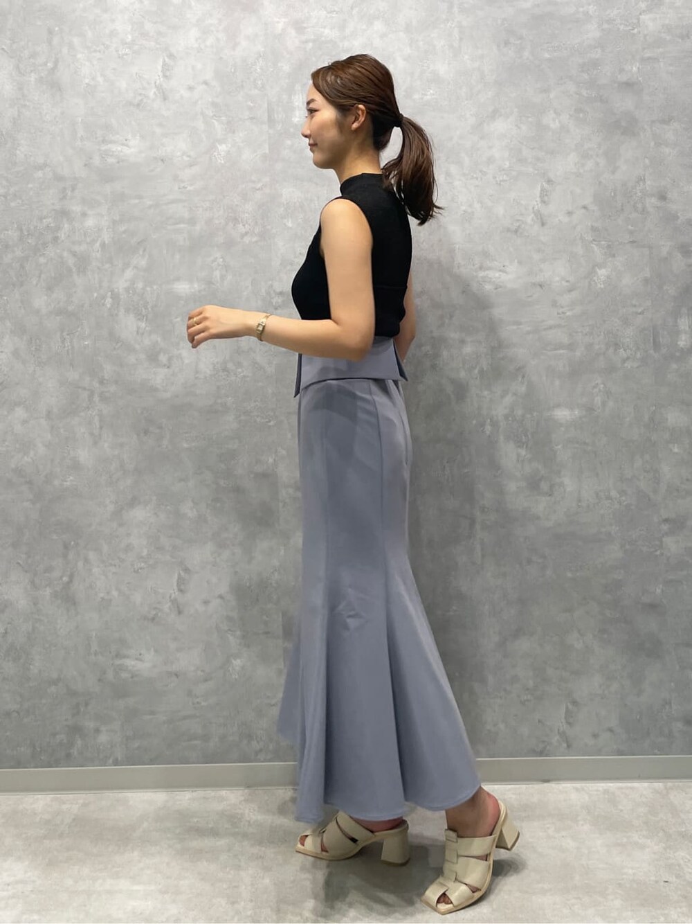 ホワイト系のサンダル、ブラック系のニット/セーター、ブルー系のスカートを着用したレディースの夏コーディネートの4枚目の写真