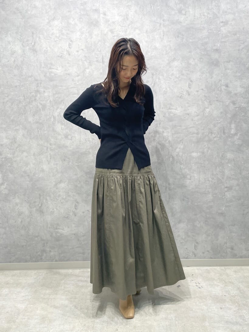 ベージュ系のスカート、ベージュ系のブーツ、ブラック系のニット/セーターを着用したレディースの秋コーディネートの3枚目の写真