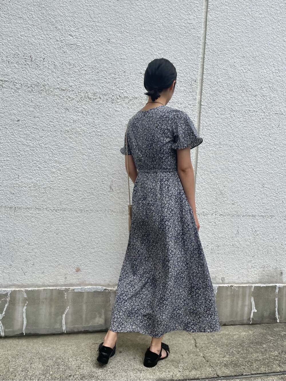 ベージュ系のハンドバッグ、ブルー系のワンピース、ゴールド系のネックレスを着用したレディースの夏コーディネートの4枚目の写真