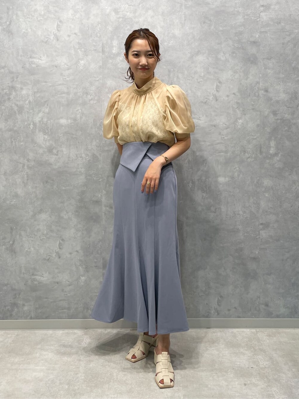 ベージュ系のシャツ/ブラウス、ホワイト系のサンダル、ブルー系のスカートを着用したレディースの夏コーディネートの2枚目の写真