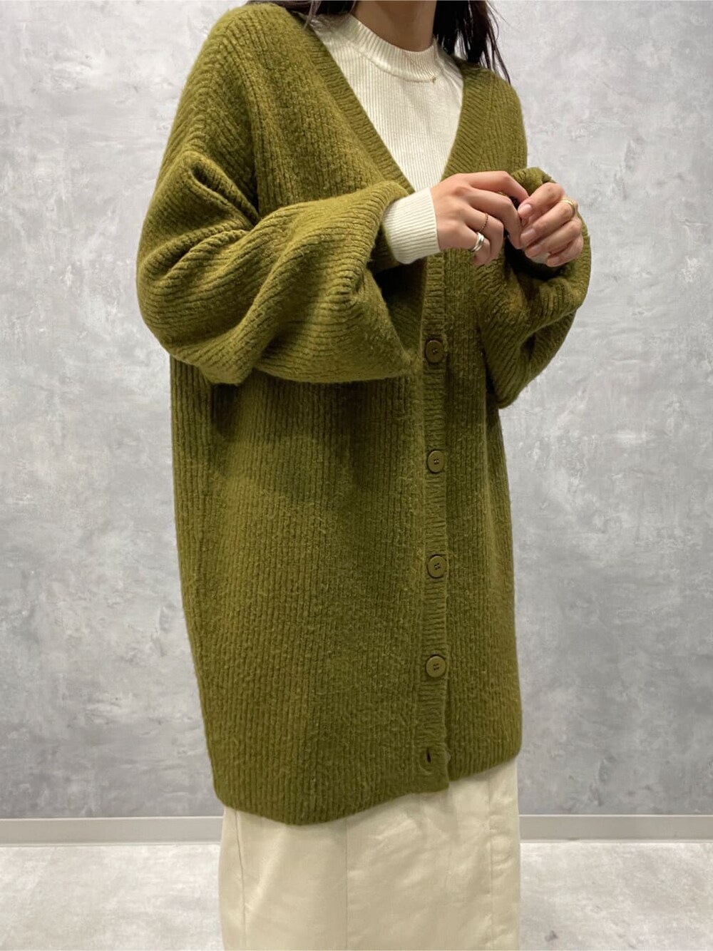 ベージュ系のブーツ、ホワイト系のニット/セーター、ホワイト系のスカートを着用したレディースの秋コーディネートの7枚目の写真