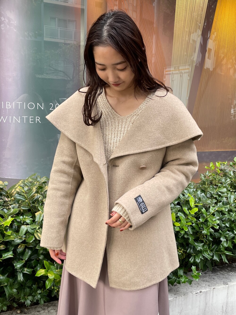 ホワイト系のニット/セーター、ホワイト系のその他アウター、ベージュ系のスカートを着用したレディースの秋コーディネートの9枚目の写真