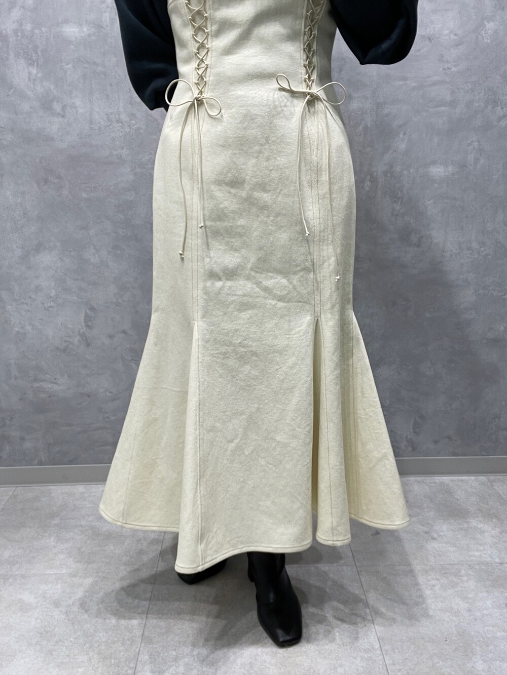 グリーン系のニット/セーター、ホワイト系のカーディガン/ボレロ、ブラック系のブーツを着用したレディースの冬コーディネートの10枚目の写真