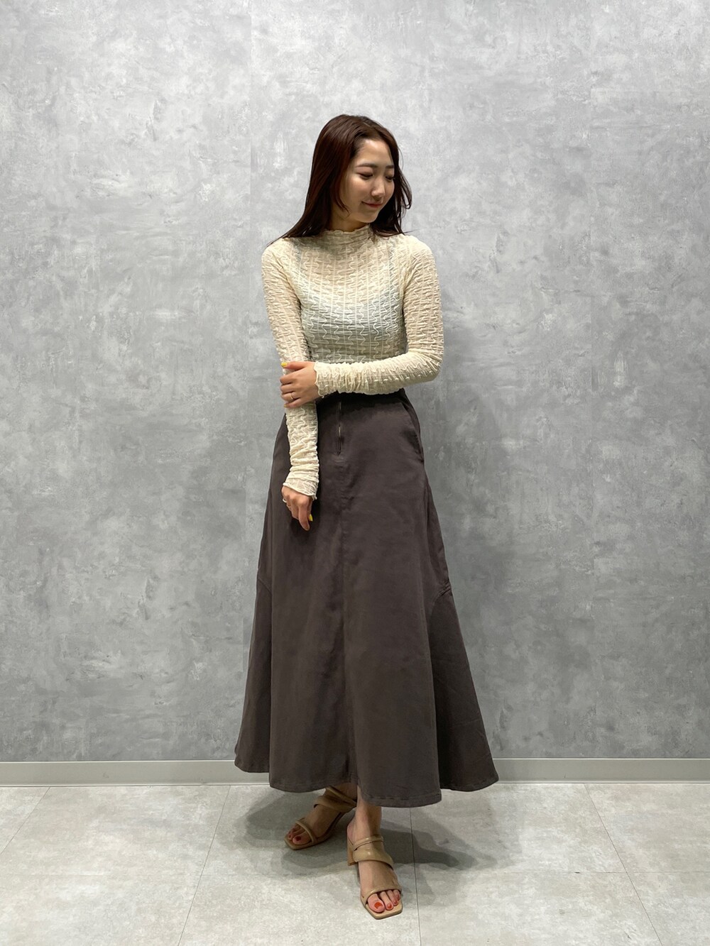 ベージュ系のサンダル、グレー系のスカート、ホワイト系のTシャツ/カットソーを着用したレディースの春コーディネートの2枚目の写真