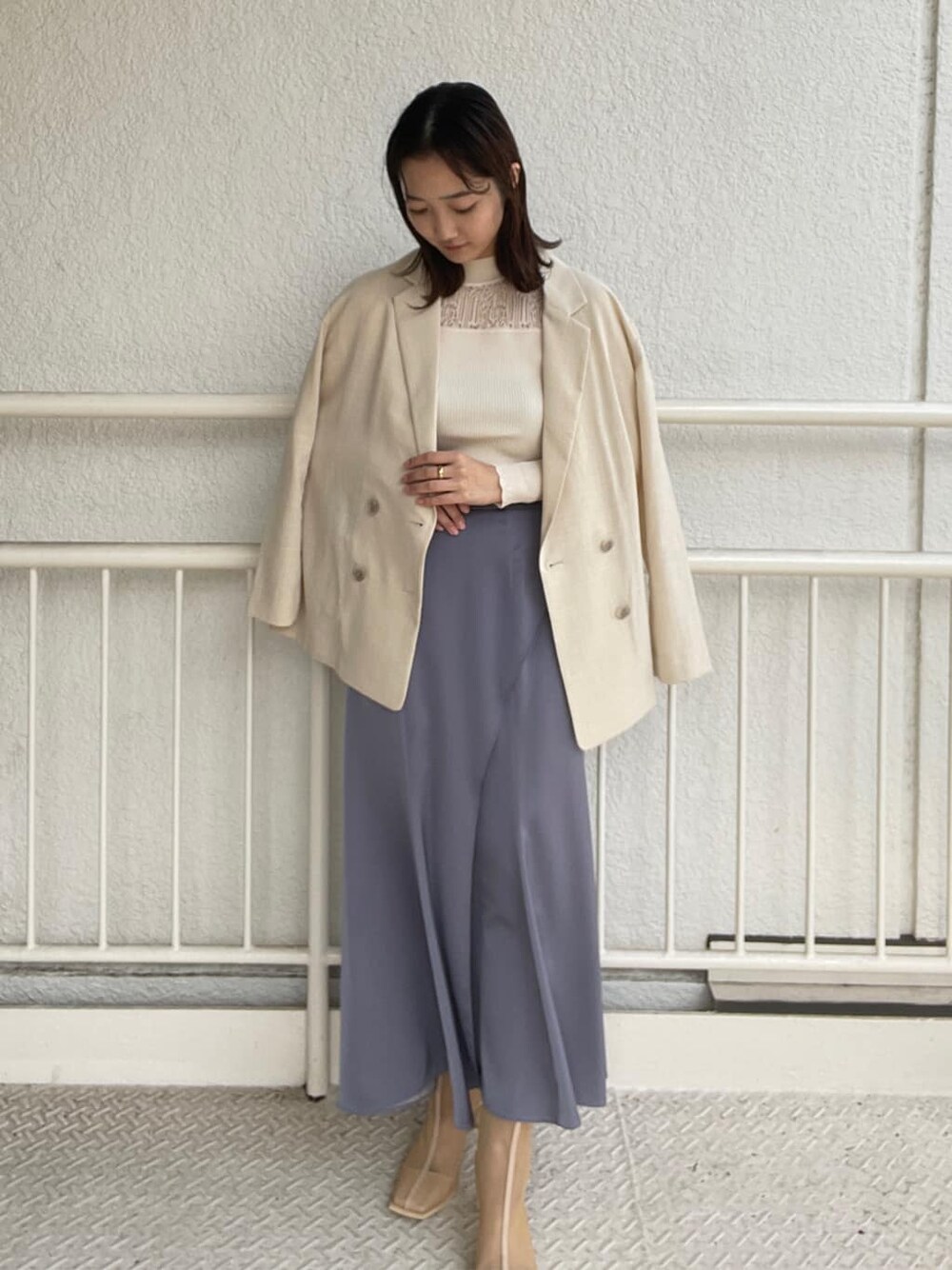 ホワイト系のニット/セーター、ベージュ系のブーツ、ブルー系のスカートを着用したレディースの春コーディネートの3枚目の写真