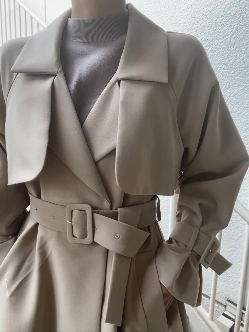 ベージュ系のトレンチコート、グレー系のワンピース、ベージュ系のブーツを着用したレディースの春コーディネートの5枚目の写真