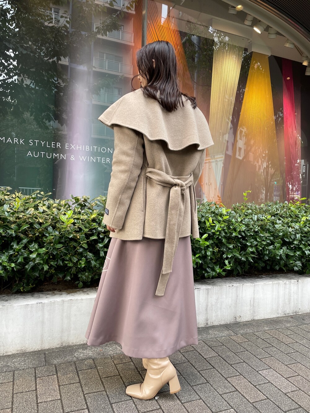 ホワイト系のニット/セーター、ホワイト系のその他アウター、ベージュ系のスカートを着用したレディースの秋コーディネートの2枚目の写真