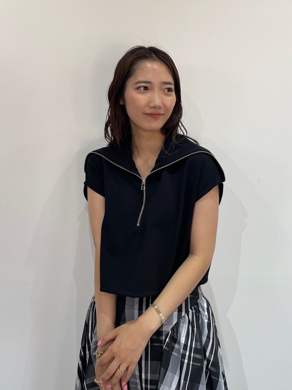 ブラック系のTシャツ/カットソー、ブラック系のパンプス、ホワイト系のスカートを着用したレディースの夏コーディネートの7枚目の写真