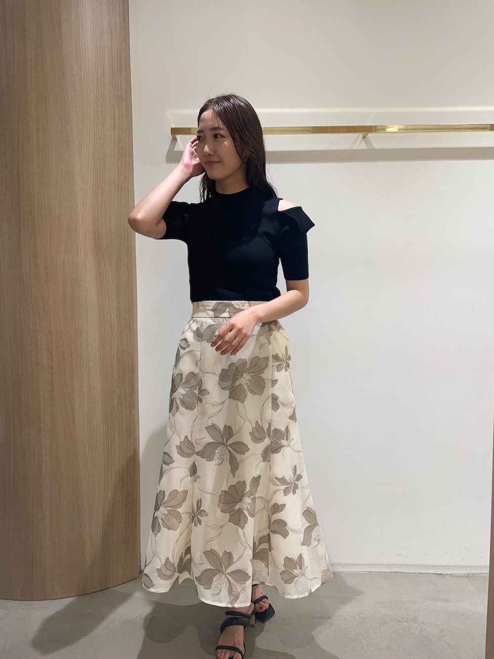 ブラック系のニット/セーター、ブラック系のサンダル、ベージュ系のスカートを着用したレディースの春コーディネートの7枚目の写真