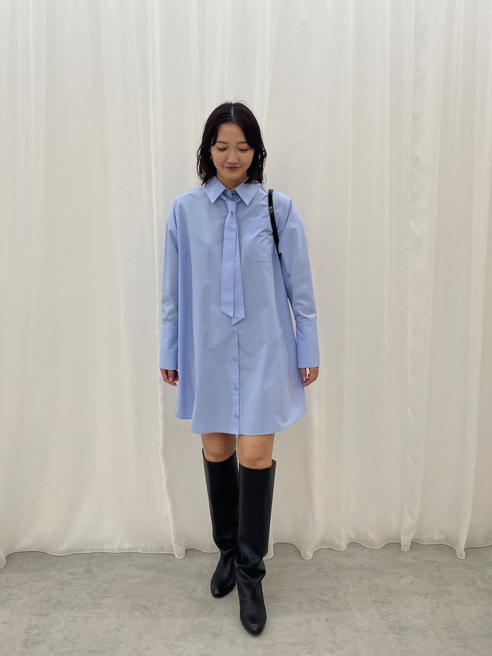 ブルー系のシャツワンピース、ブラック系のショルダーバッグを着用したレディースの秋コーディネートの3枚目の写真