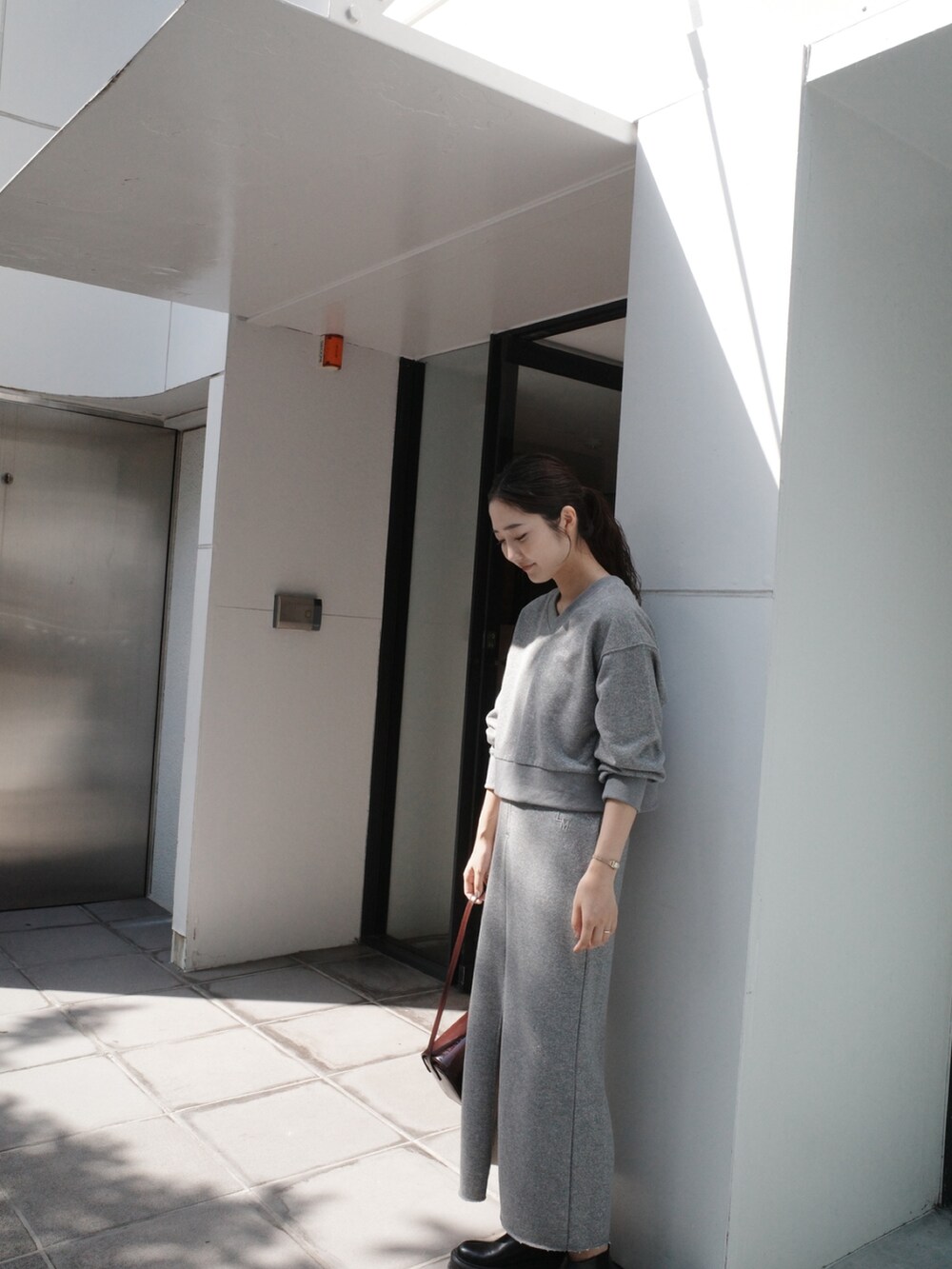 グレー系のスカート、グレー系のスウェット、ブラック系のブーツを着用したレディースの夏コーディネートの6枚目の写真