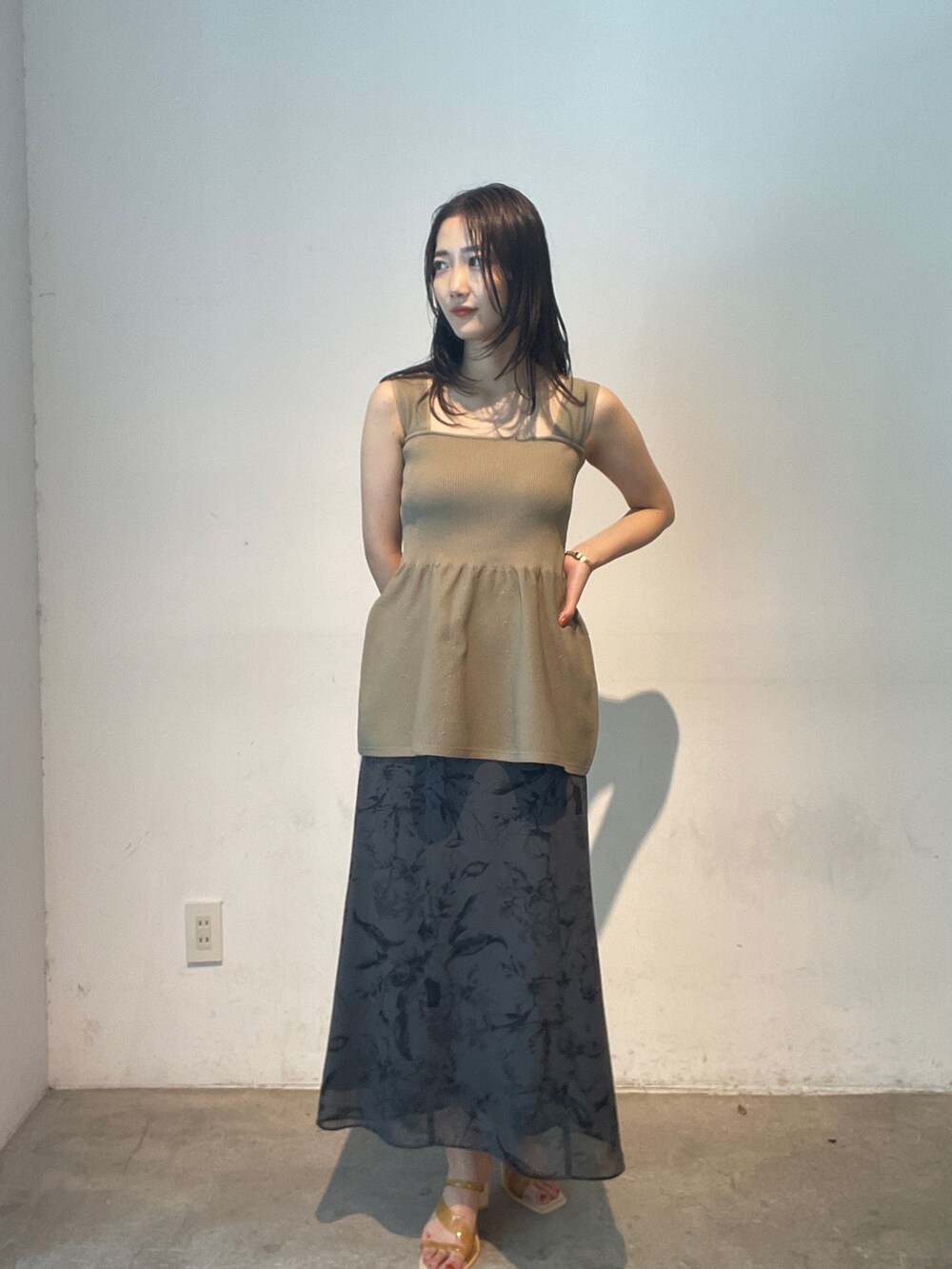 グレー系のスカート、イエロー系のサンダル、ベージュ系のニット/セーターを着用したレディースの夏コーディネートの5枚目の写真