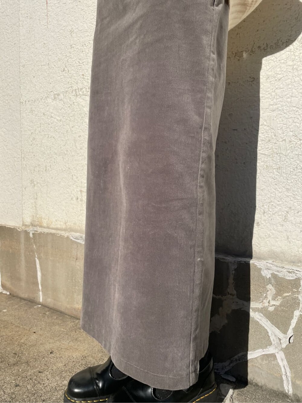 グレー系のスカート、ホワイト系のニット/セーターを着用したレディースの冬コーディネートの6枚目の写真