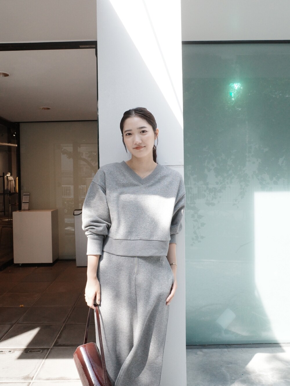 グレー系のスカート、グレー系のスウェット、ブラック系のブーツを着用したレディースの夏コーディネートの4枚目の写真