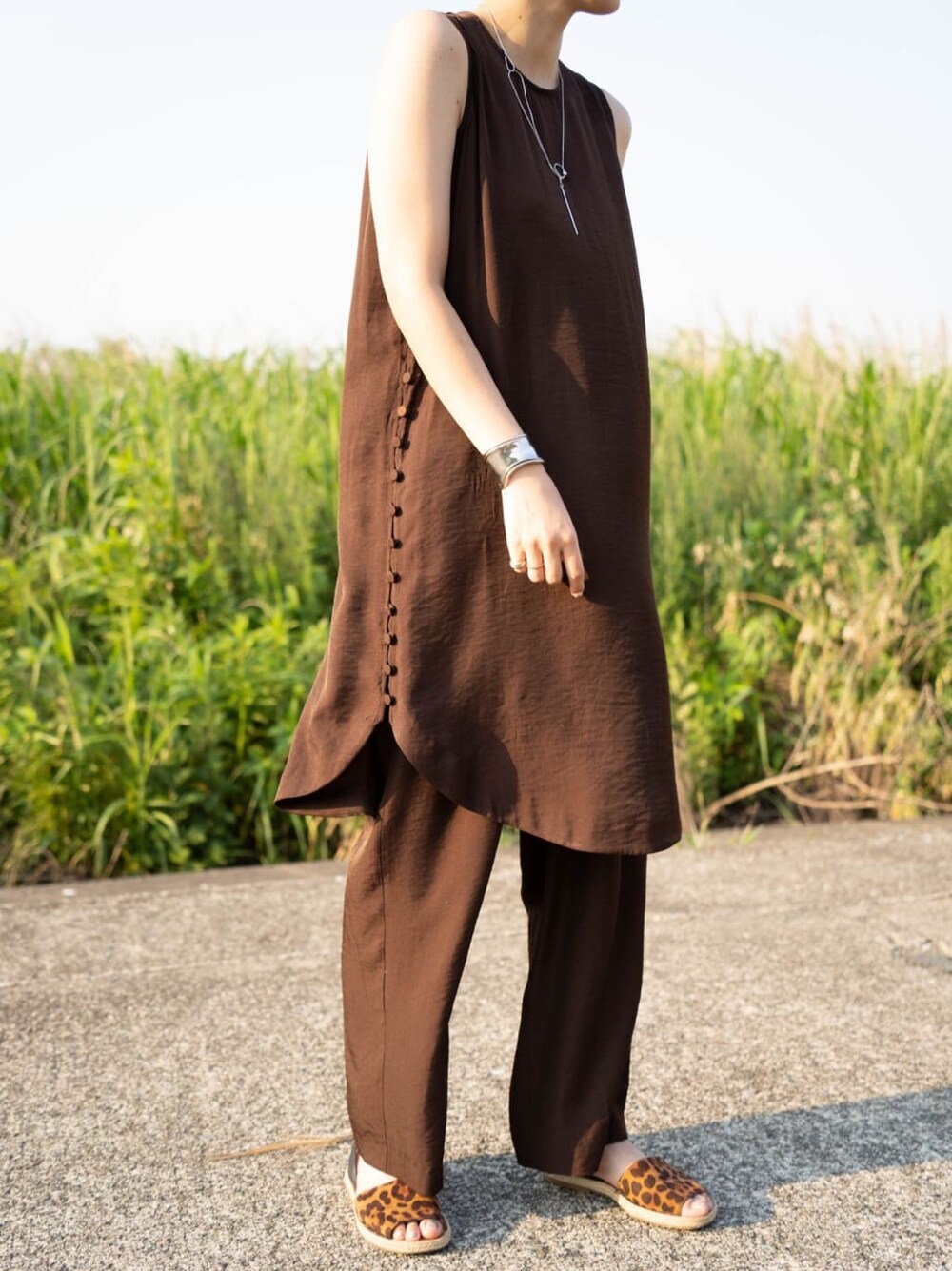 ブラウン系のワンピース、シルバー系のバングル/リストバンドを着用したレディースの夏コーディネートの2枚目の写真