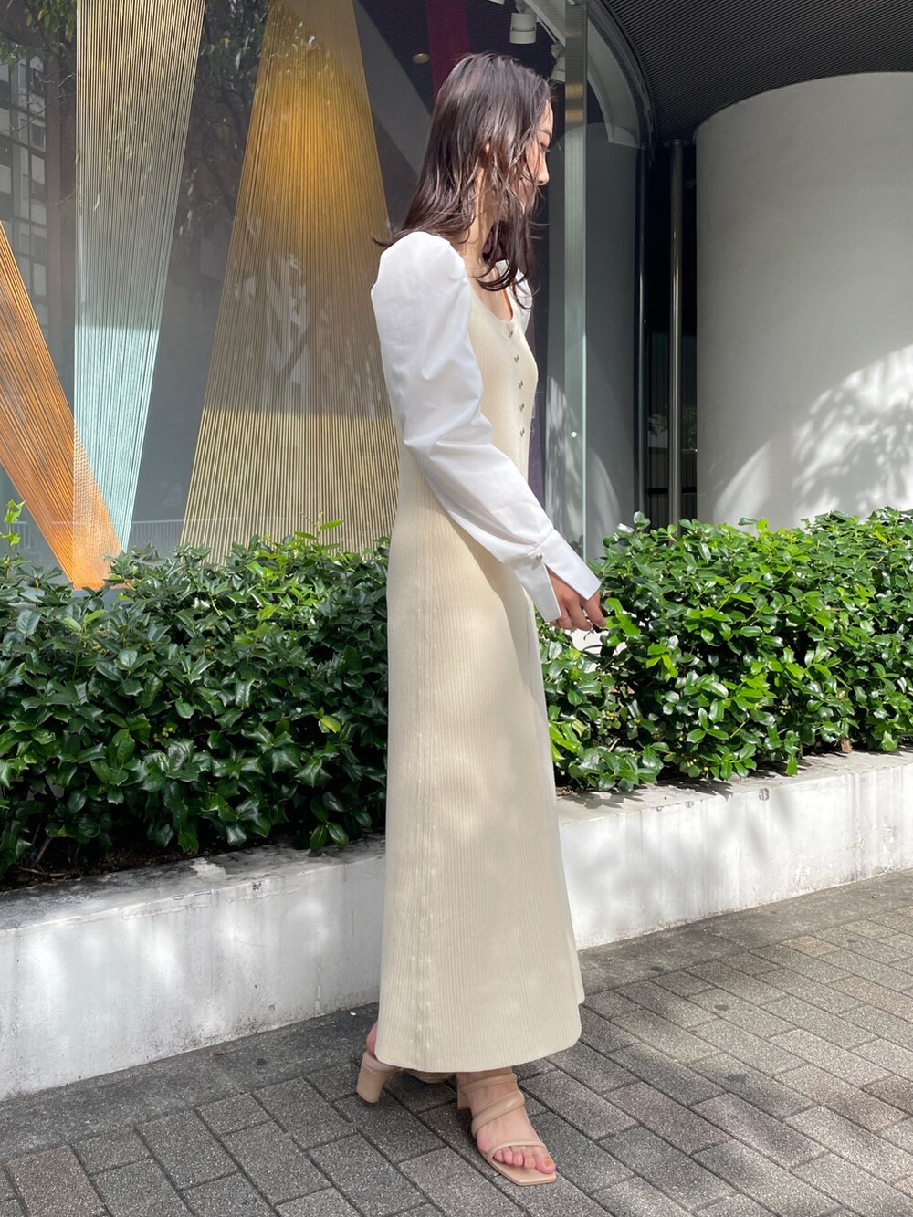 ホワイト系のワンピース、ベージュ系のサンダルを着用したレディースの冬コーディネートの6枚目の写真