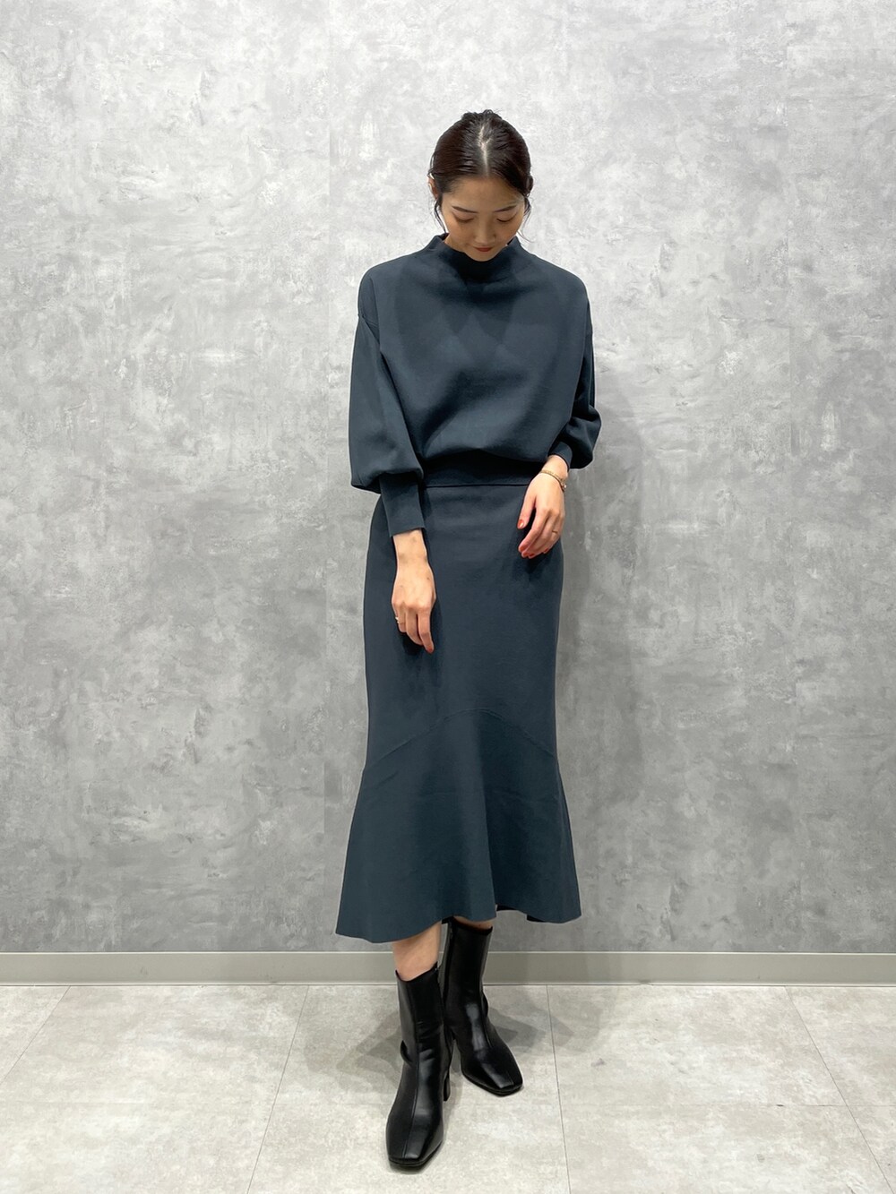 ホワイト系のカーディガン/ボレロ、グリーン系のニット/セーター、グリーン系のスカートを着用したレディースの冬コーディネートの5枚目の写真