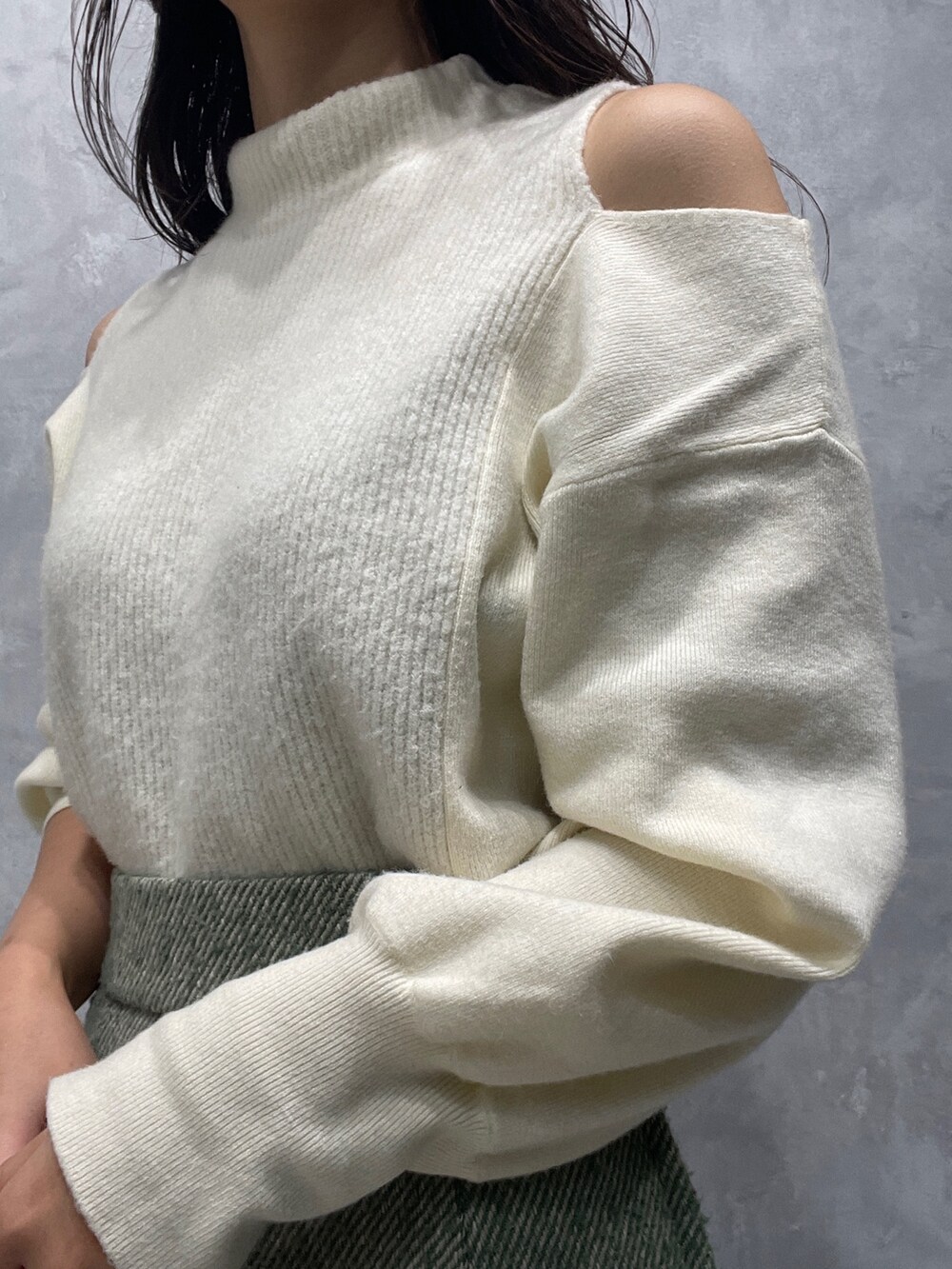 ベージュ系のブーツ、ホワイト系のニット/セーター、グリーン系のスカートを着用したレディースの冬コーディネートの8枚目の写真