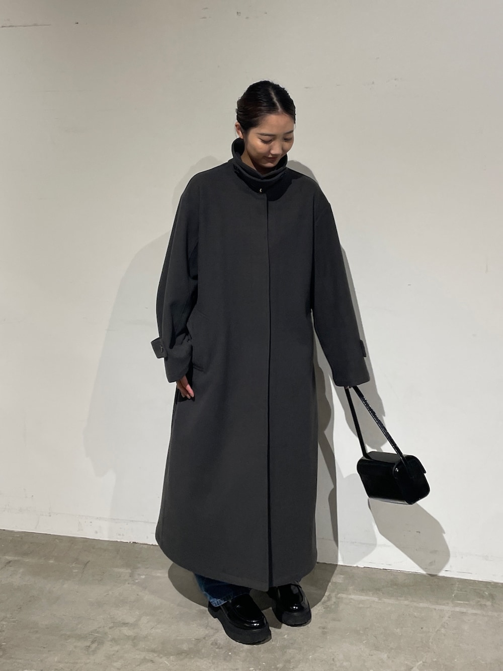 ブルー系のデニムパンツ、グレー系のステンカラーコート、ブラック系のローファーを着用したレディースの夏コーディネートの5枚目の写真