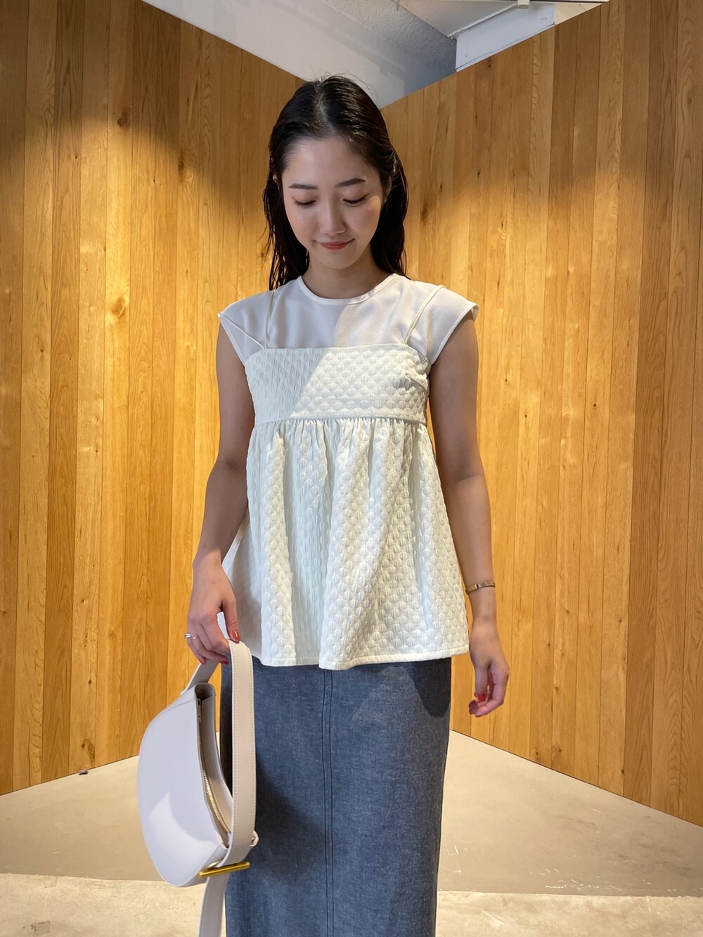 その他のサンダル、ホワイト系のハンドバッグ、ブルー系のスカートを着用したレディースの春コーディネートの5枚目の写真