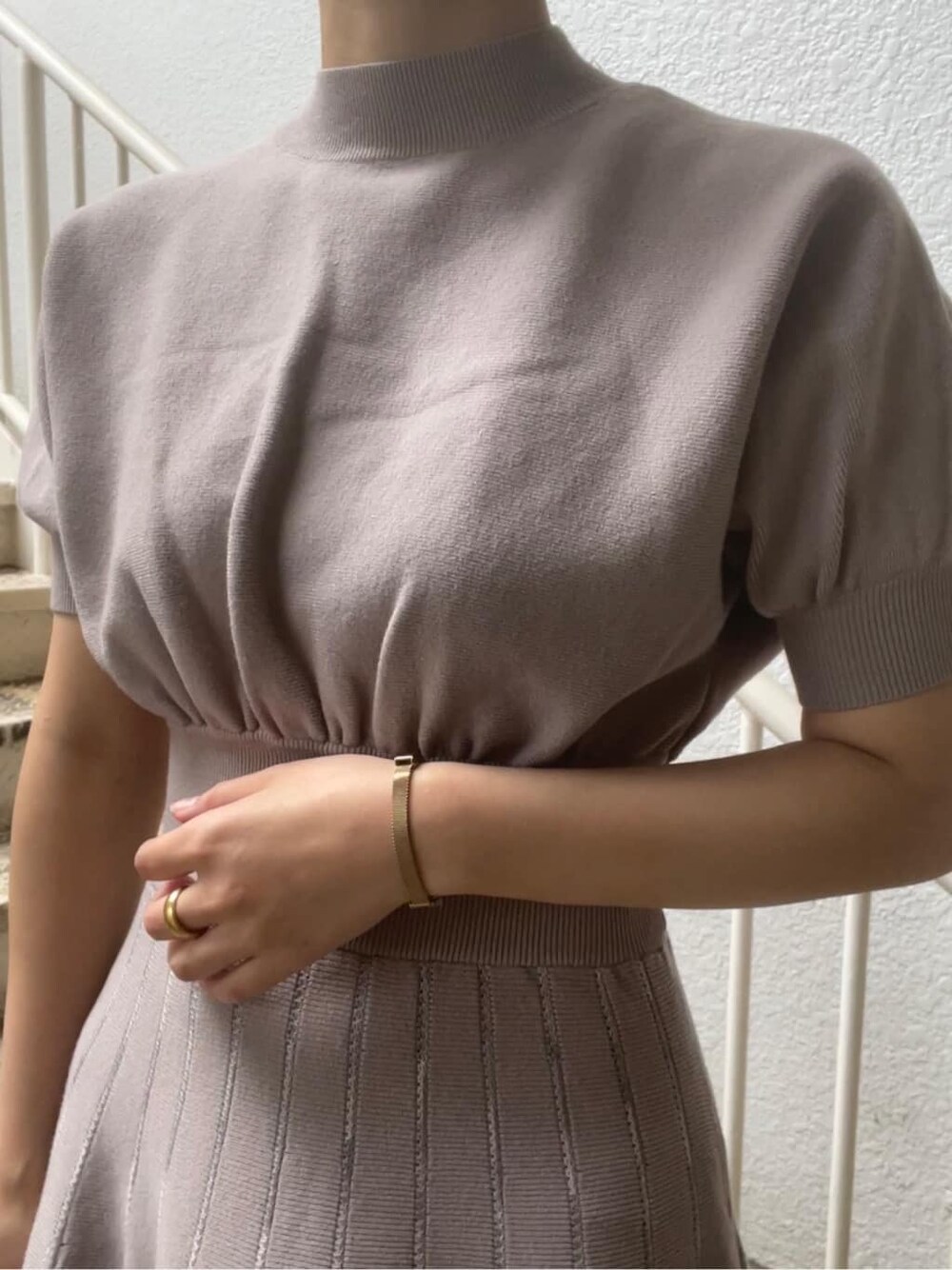 ベージュ系のトレンチコート、グレー系のワンピース、ベージュ系のブーツを着用したレディースの春コーディネートの9枚目の写真