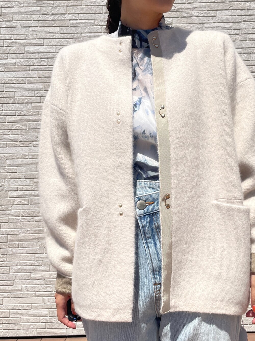 ブルー系のデニムパンツ、ブルー系のシャツ/ブラウス、ホワイト系のカーディガン/ボレロを着用したレディースの秋コーディネートの5枚目の写真