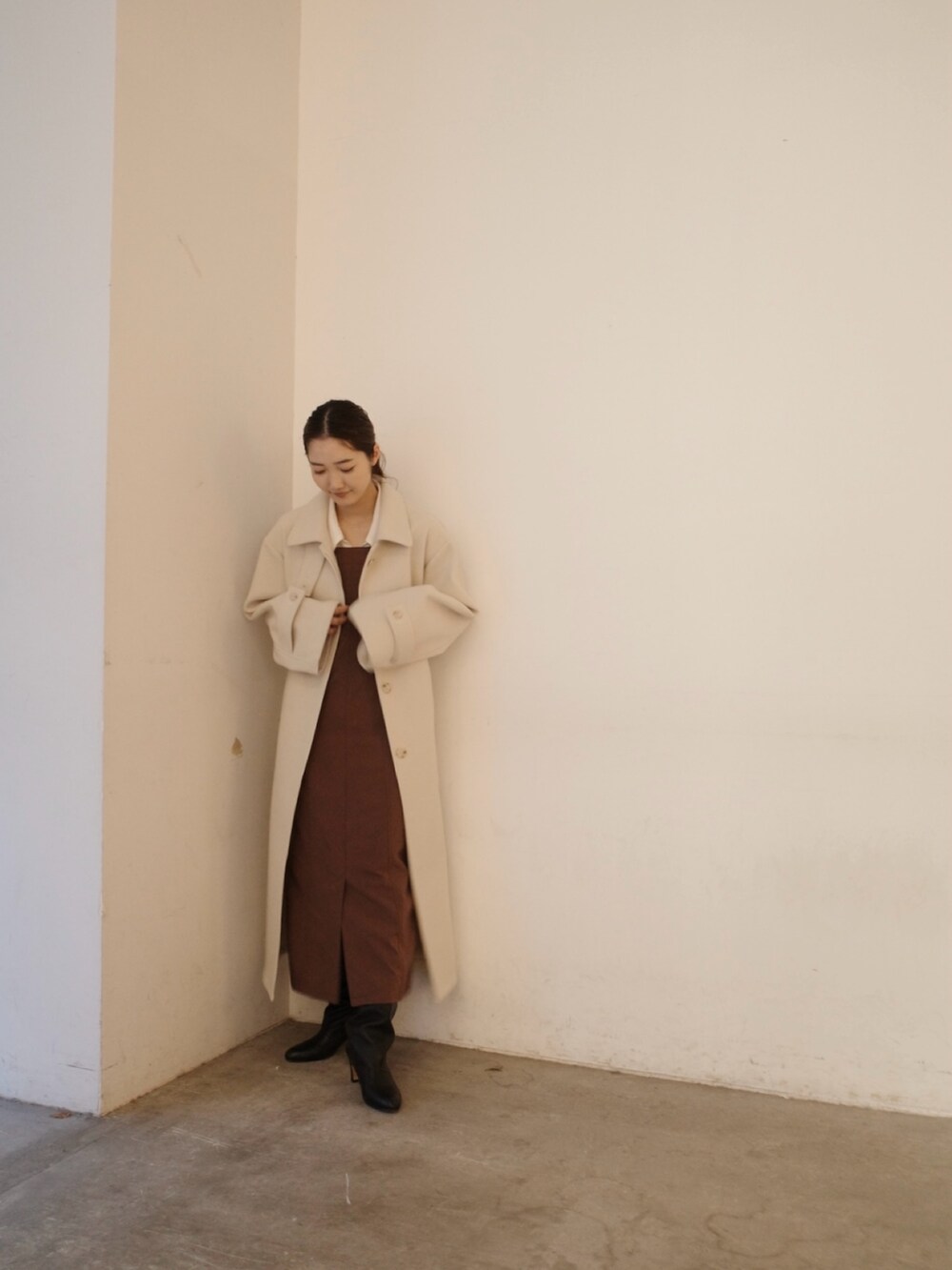 グレー系のステンカラーコート、ブラウン系のワンピースを着用したレディースの秋コーディネートの5枚目の写真