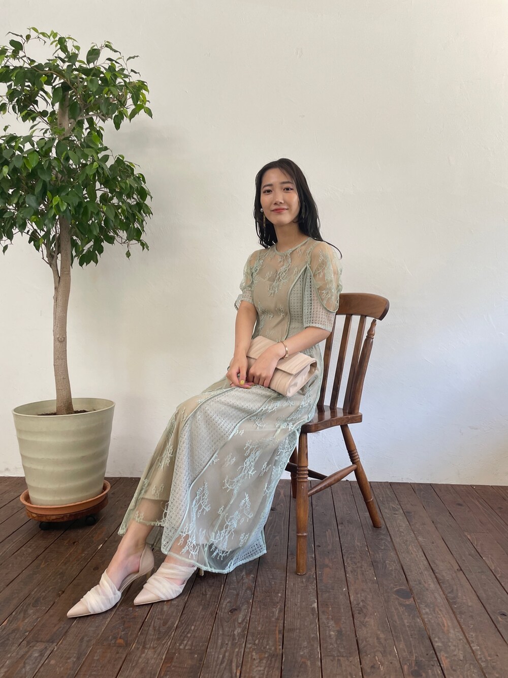 グリーン系のドレス、ベージュ系のハンドバッグ、ベージュ系のパンプスを着用したレディースの春コーディネートの7枚目の写真