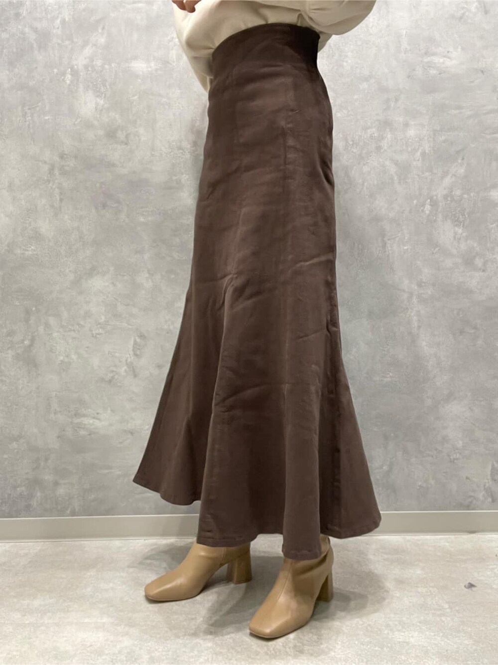 ベージュ系のブーツ、ブラウン系のスカート、イエロー系のカーディガン/ボレロを着用したレディースの秋コーディネートの10枚目の写真