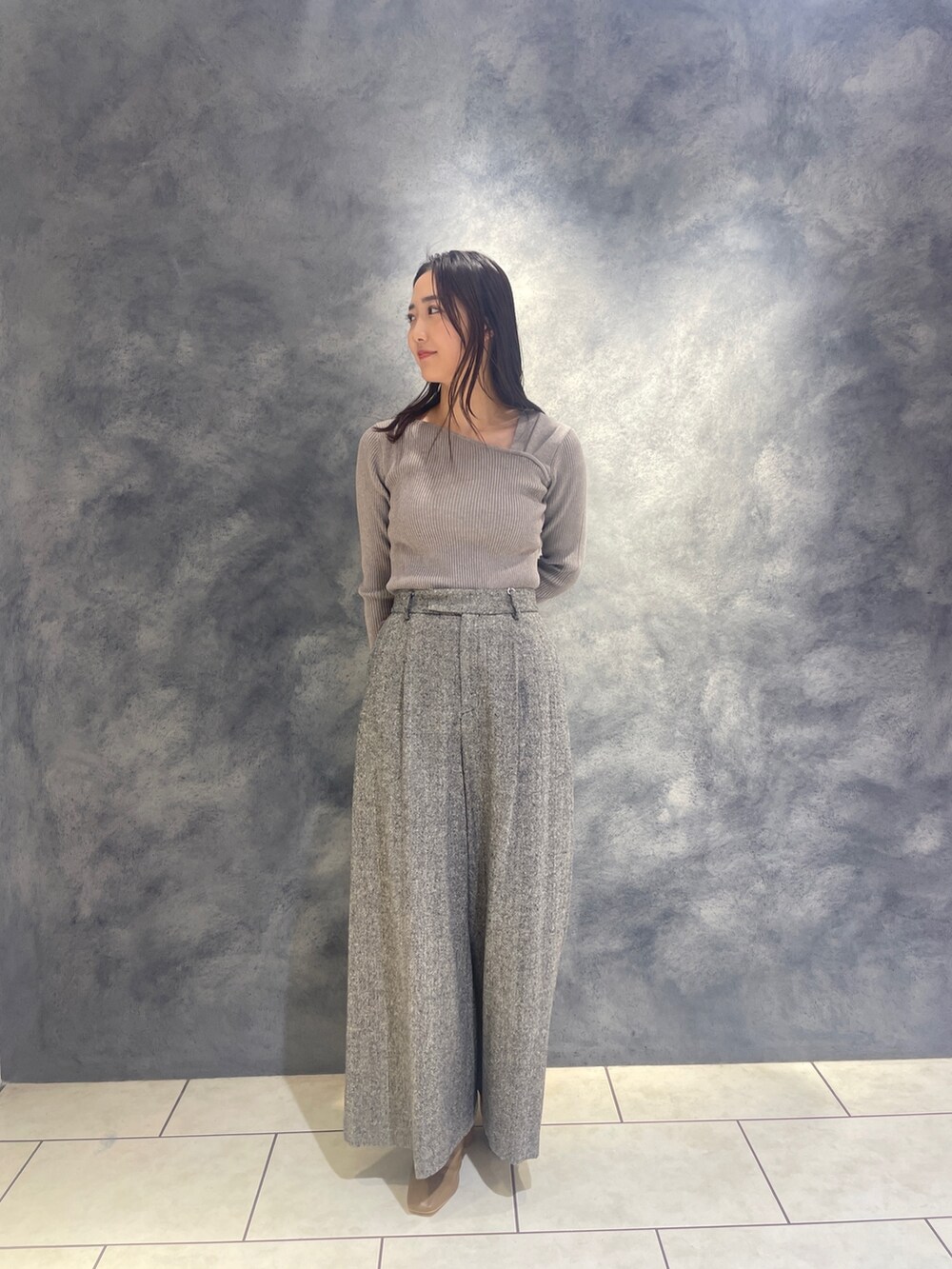 ホワイト系のノーカラーコート、グレー系のニット/セーター、ブラック系のその他パンツを着用したレディースの秋コーディネートの6枚目の写真