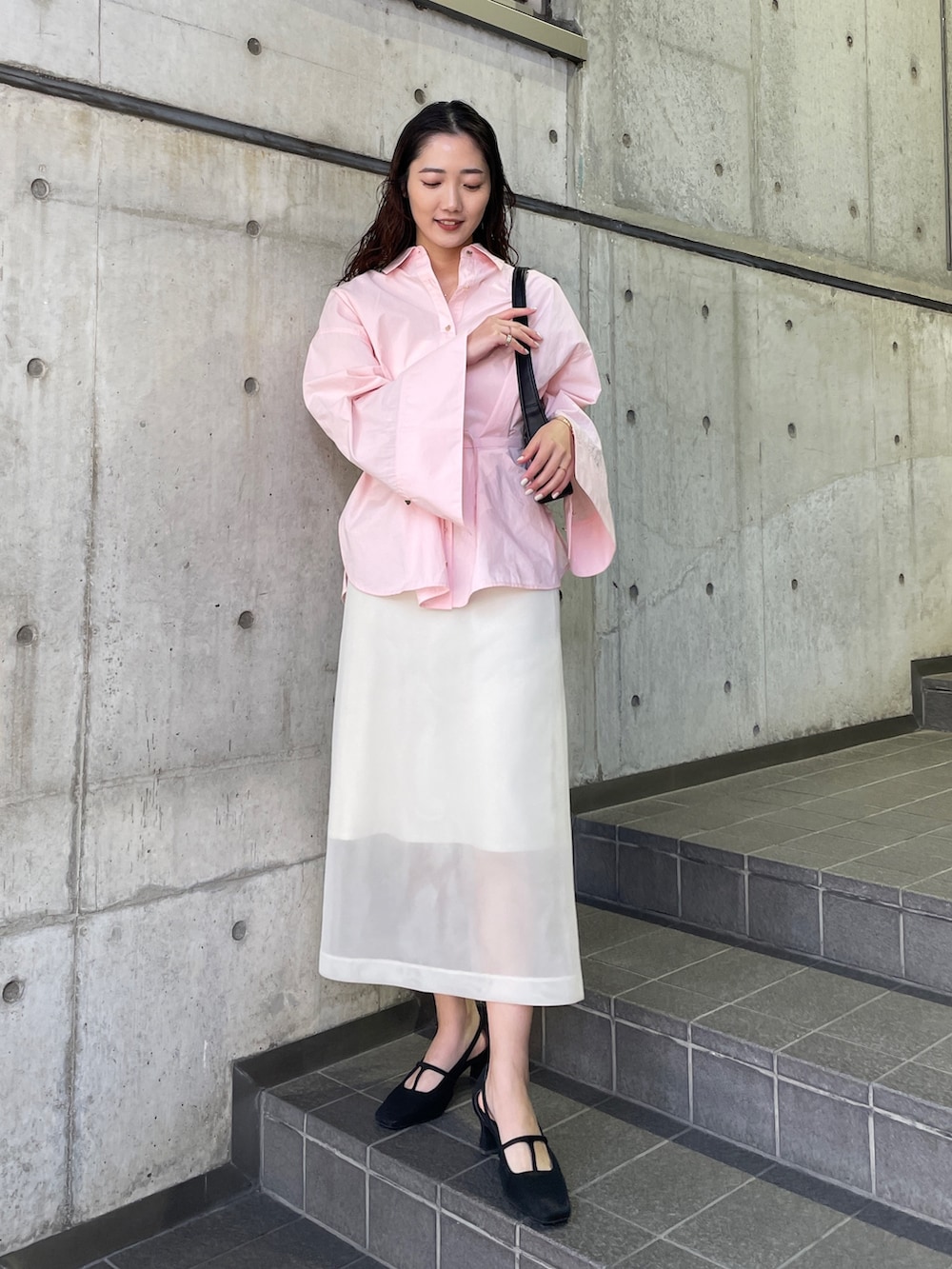 ピンク系のシャツ/ブラウス、ブラック系のパンプス、ホワイト系のスカートを着用したレディースの冬コーディネートの5枚目の写真