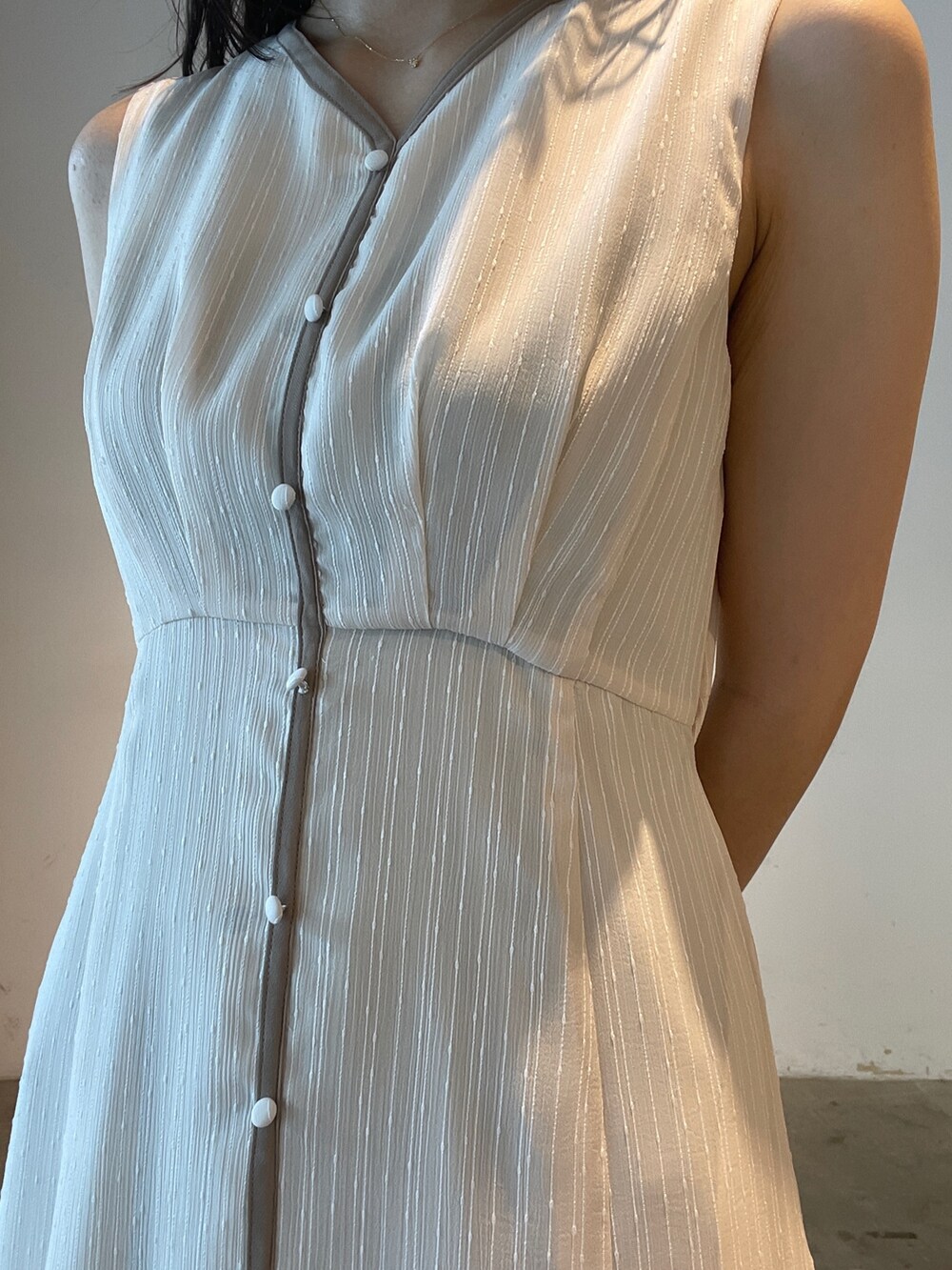 イエロー系のサンダル、ブルー系のテーラードジャケット、ホワイト系のワンピースを着用したレディースの夏コーディネートの9枚目の写真