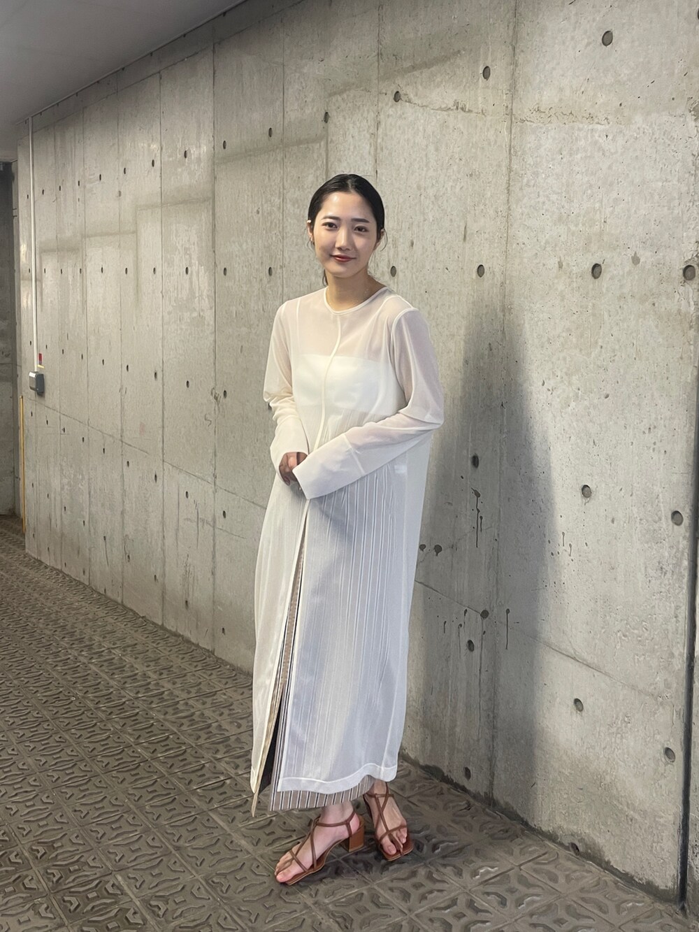 ホワイト系のTシャツ/カットソー、ベージュ系のスカート、ブラウン系のサンダルを着用したレディースの春コーディネートの4枚目の写真